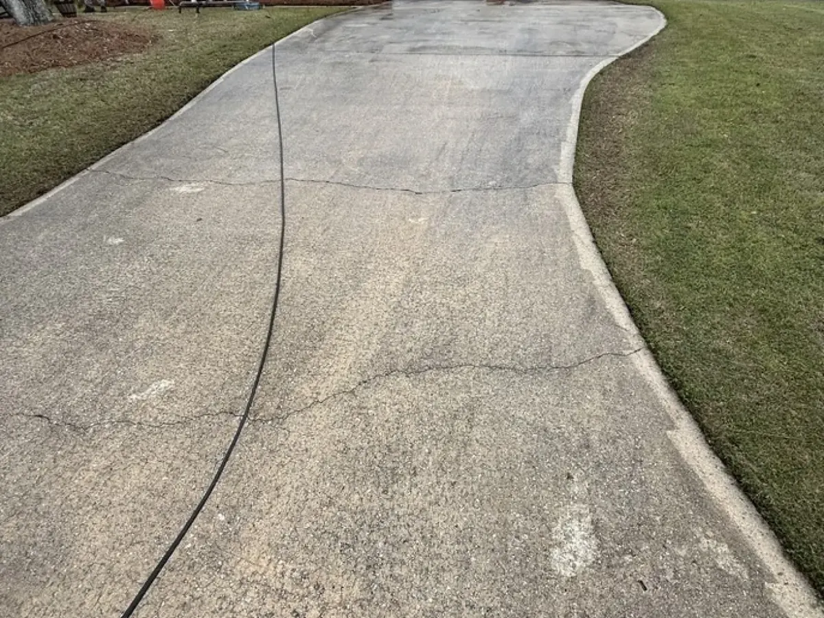 The same Augusta driveway before pressure washing, gray with mildew and dirt