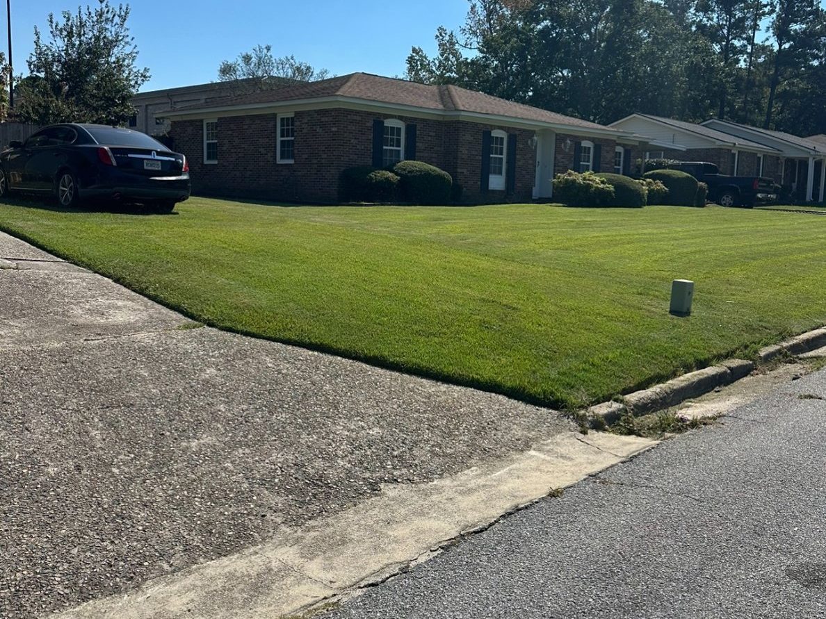 Mowed and edged front lawn at a brick home