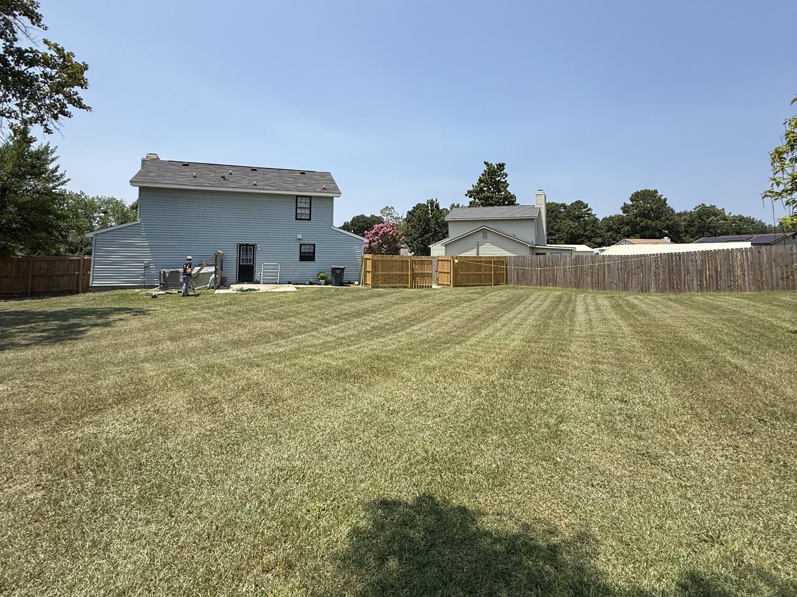 Freshly striped backyard lawn mowed by Anything Exterior